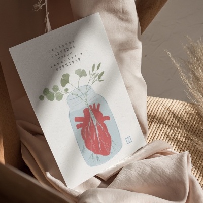 Carteira decorativa com ilustração de coração em frasco e folhas verdes sobre tecido e cadeira de madeira