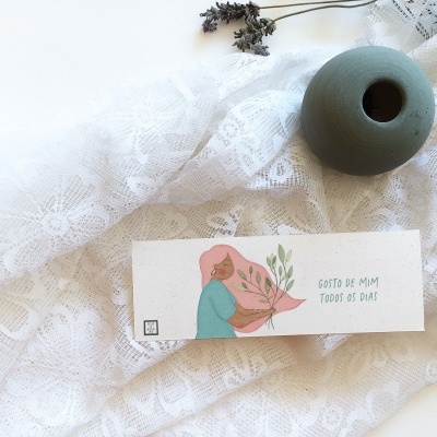 Vaso cerâmico verde, etiqueta com ilustração e texto em tecido branco rendado