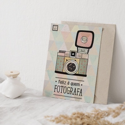 Placa decorativa com desenho de câmara fotográfica vintage e texto em português sobre superfície branca