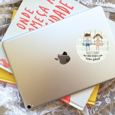 Tablet prata com autocolante e livros coloridos sobre tecido rendado branco