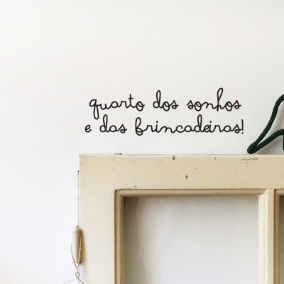 Decoração de parede com moldura de janela, dinossauro iluminado e texto em português