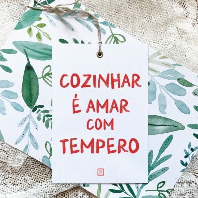 Cartão com frase em vermelho sobre padrão de folhas verdes em tecido rendado