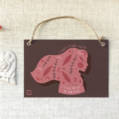 Placa decorativa com silhueta feminina e ornamento de coração sobre fundo bege