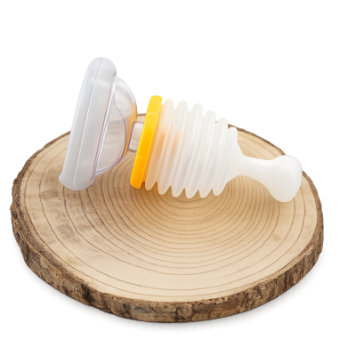 Sugador nasal branco com anel amarelo sobre disco de madeira