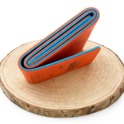 Correia de bicicleta dobrada laranja e azul sobre disco de madeira