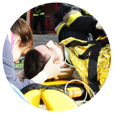 Paciente com cobertor térmico dourado em maca amarela, assistido por socorrista