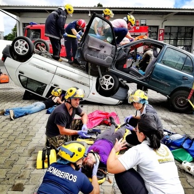 Simulação de resgate com carros em acidente e equipa de bombeiros a prestar socorro