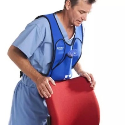 Homem com colete azul sobre uniforme azul claro apoiado em cadeira vermelha