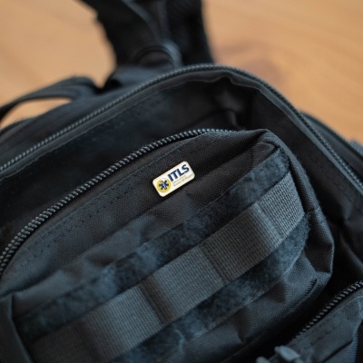 Mochila preta com etiqueta TTLS perto do fecho de correr