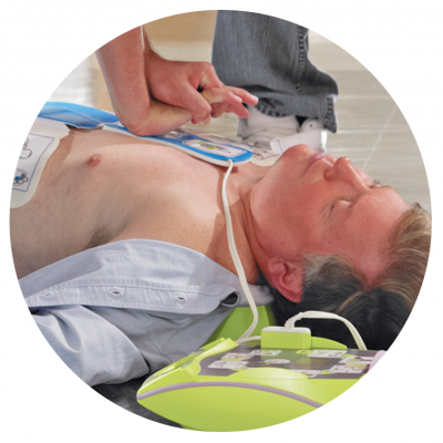 Homem no chão a receber desfibrilhação com desfibrilhador e compressões torácicas