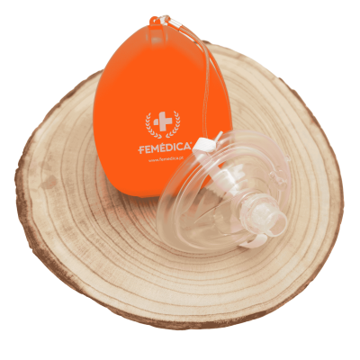 Máscara transparente e bolsa laranja FEMÉDICA sobre base de madeira