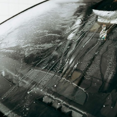 Vidro dianteiro de carro molhado com gotas de água