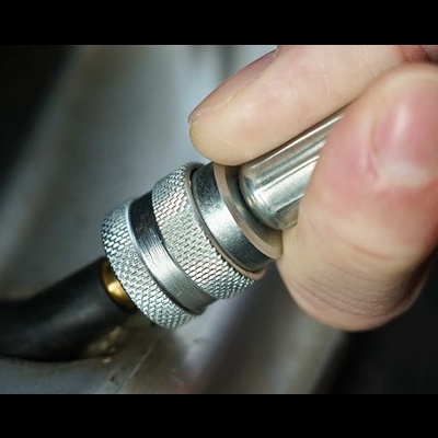 Mão segurando ferramenta metálica prateada com ponta preta