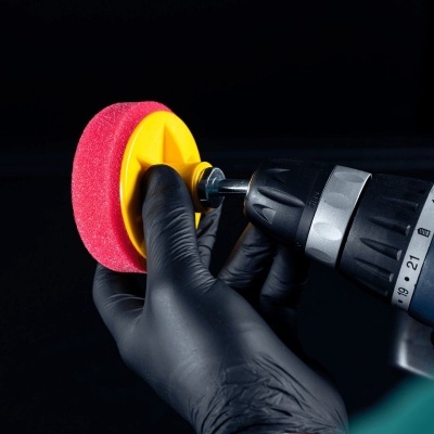 Esponja polidora vermelha com suporte amarelo e furadeira preta