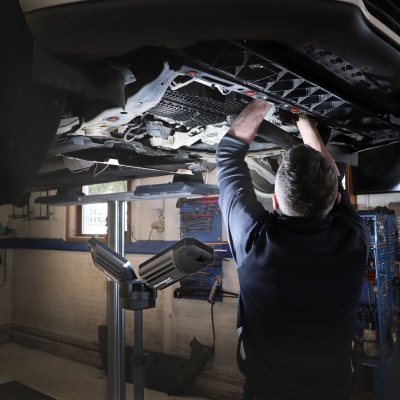 Iluminação portátil preta ajustável em oficina sob carro elevado