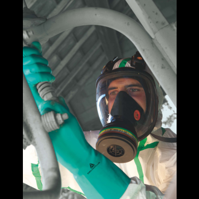 Pessoa com equipamento de proteção, máscara e luvas manuseando objeto tubular