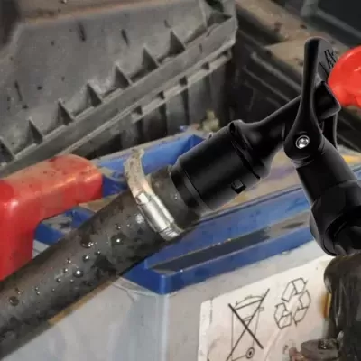 Bateria de carro com símbolos de aviso e mão com luva preta operando ferramenta