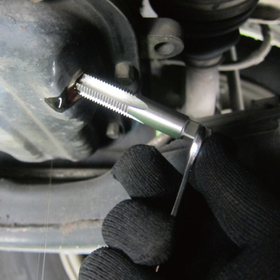 ferramenta metálica sendo usada em peça de maquinaria automóvel