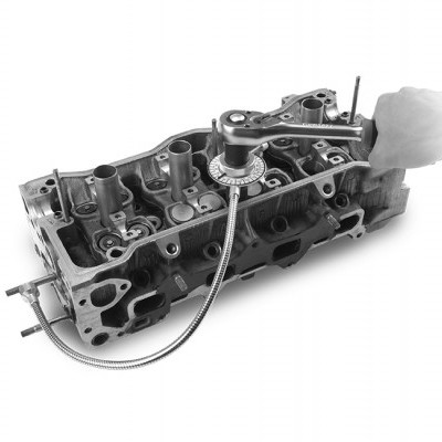 Cabeça de motor automóvel metálica com ferramenta e mão a segurá-la