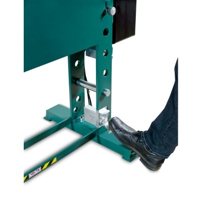 Equipamento metálico verde com ajuste de altura e pedal acionado por pé com sapato preto