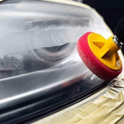 Pano de polimento amarelo com esponja vermelha a limpar superfície metálica