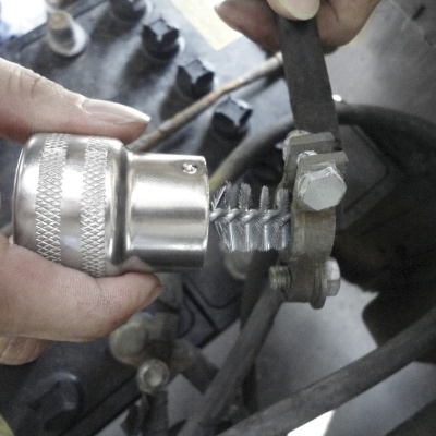 Ferramenta metálica prateada a ser usada numa peça dentada num ambiente industrial.