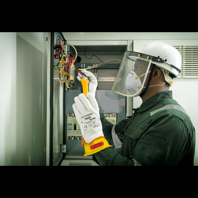 Homem com roupa de proteção mexe em painel elétrico com fios coloridos