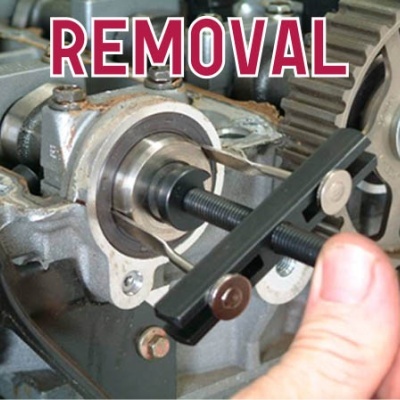 Ferramenta de remoção preta em peça de motor com engrenagens e parafusos, texto REMOVAL em vermelho.