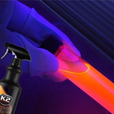 Spray K2 e tubo iluminado em ambiente escuro com luz azul