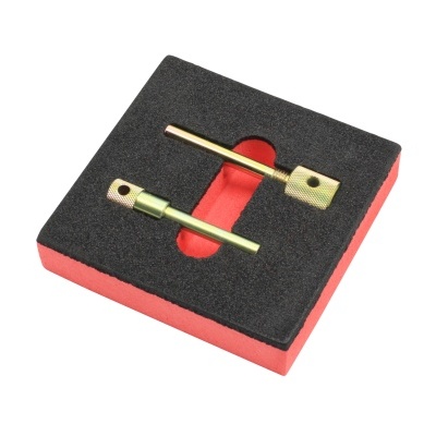 duas peças metálicas douradas numa base de espuma preta e vermelha