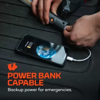 Smartphone a carregar ligado a power bank portátil sobre superfície preta texturizada