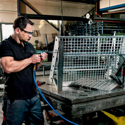 Homem a trabalhar numa estrutura metálica em fábrica