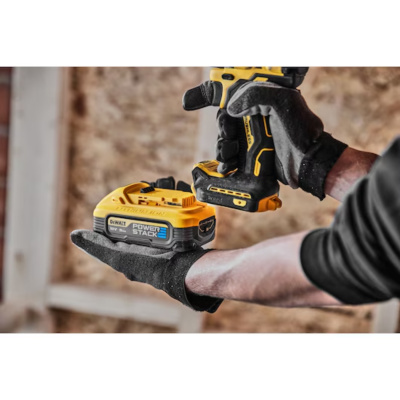 Bateria DEWALT POWER STACK 10,8V preta e amarela segurada por mão com luva preta