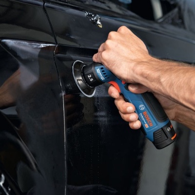Homem a polir carro preto com lixadora Bosch azul