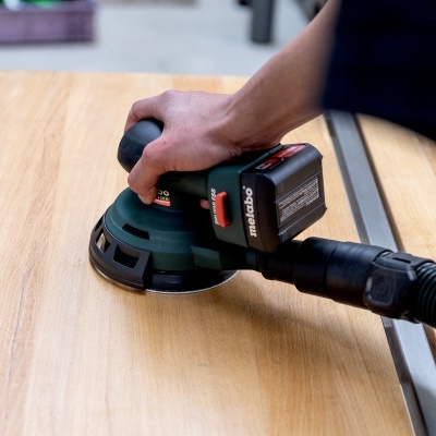 Máquina lixadora Metabo a lixar madeira clara com mangueira de aspiração