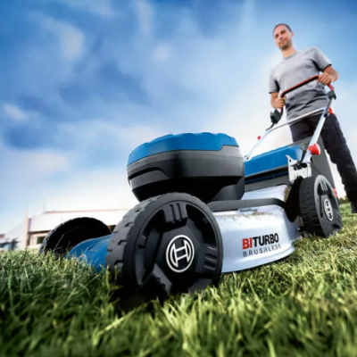cortador de relva Bosch BATURBO BRUSHLSS numa área verde com homem a empurrá-lo