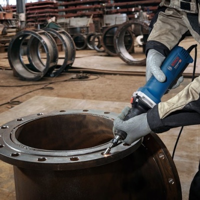 Trabalhador a usar ferramenta elétrica BOSCH numa peça metálica em oficina