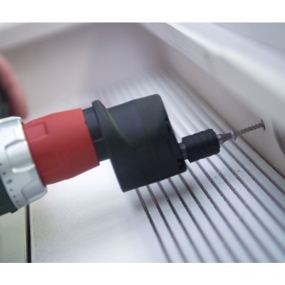 Parafusadeira elétrica a parafusar parafuso numa superfície branca com ranhuras