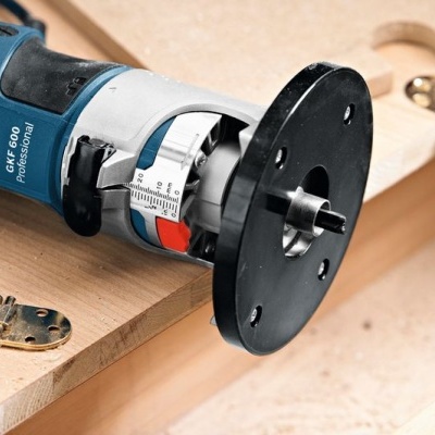 Tupia elétrica BOSCH azul e preta sobre madeira com dobradiças metálicas