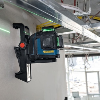 Nível a laser preto e azul instalado numa parede numa obra