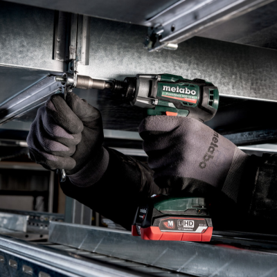 Parafusadora elétrica Metabo a bateria em uso com luvas pretas