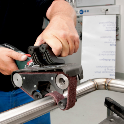 Pessoa a usar lixadora elétrica para tubo metálico