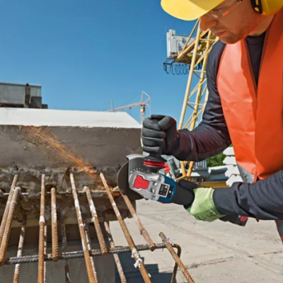 Trabalhador a usar ferramenta elétrica Bosch em obra de construção civil