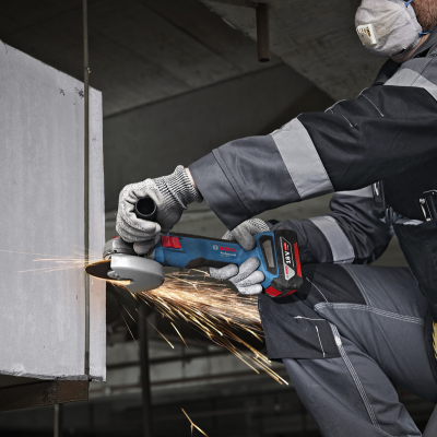 Esmerilhadora BOSCH Professional a ser usada por trabalhador com equipamento de proteção em ambiente industrial.
