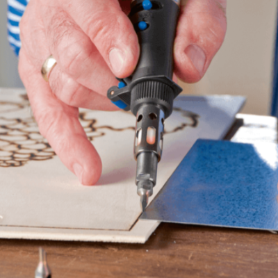 Pessoa usando ferramenta elétrica para gravar padrão em madeira