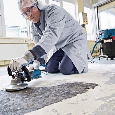 Homem de trabalho a usar máquina elétrica azul para polir pavimento