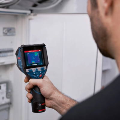 Termovisor a mostrar imagem térmica frente a quadro elétrico.