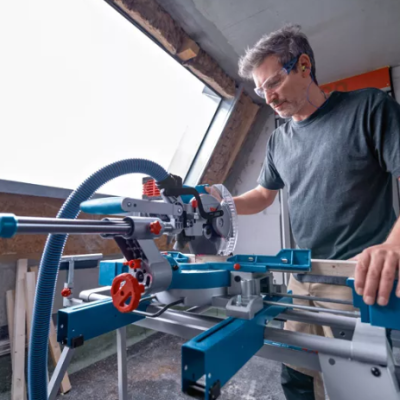 Homem a usar serra de corte numa oficina com luz natural