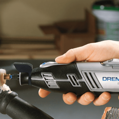 Ferramenta rotativa Dremel H580 a cortar tubo metálico preto numa oficina