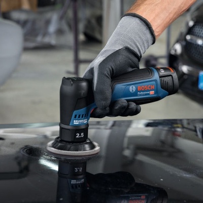 Máquina de polir BOSCH azul e preta em uso na superfície de um carro preto na oficina